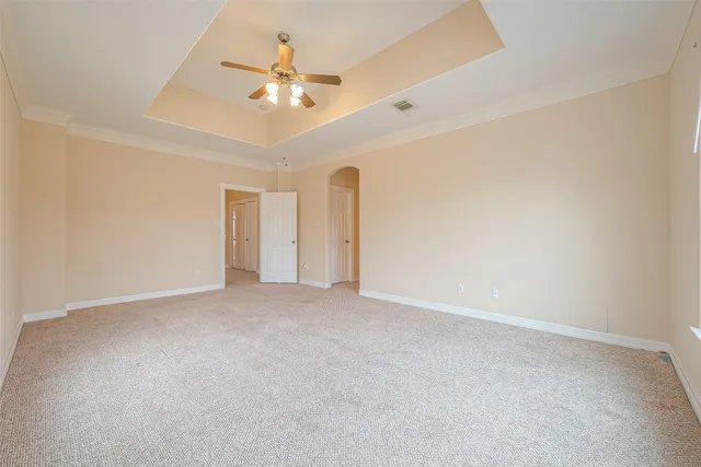 a view of an empty room with a chandelier fan