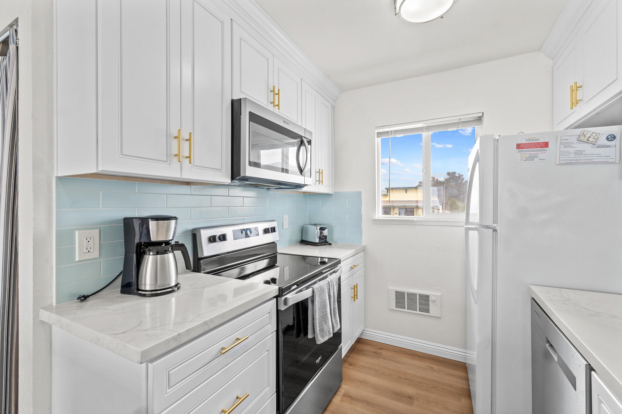 77 North Ocean Avenue, Unit 12 Cayucos, CA 93430 - Photo 17 of 41 a kitchen with stainless steel appliances granite countertop a refrigerator a stove a sink and white cabinets
