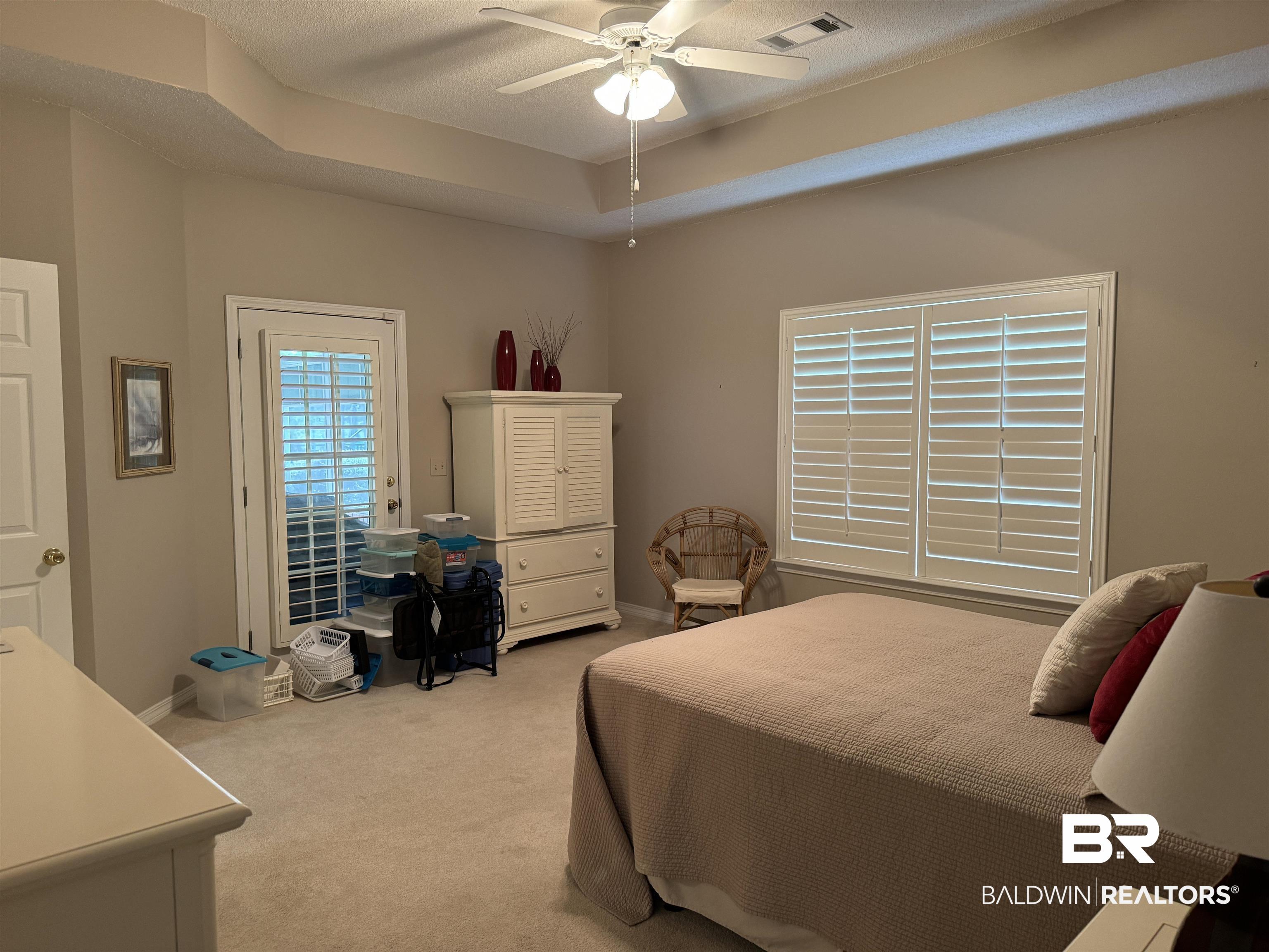 9139 Clubhouse Drive Foley, AL 36535 - Photo 20 of 30 Carpeted bedroom with a textured ceiling, ceiling fan, and a raised ceiling