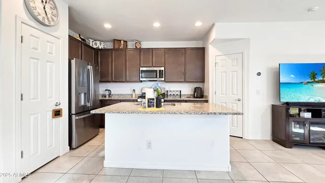 a kitchen with stainless steel appliances granite countertop a refrigerator a stove and a sink