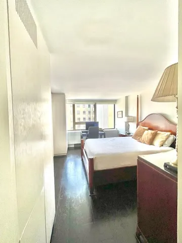 a bedroom with a bed and a large window