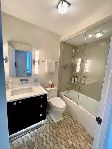 a bathroom with a sink a toilet a mirror and shower