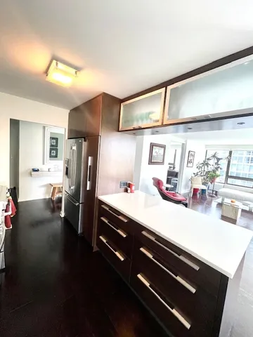 a kitchen with stainless steel appliances a sink dishwasher and refrigerator with wooden floor