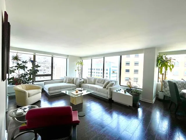 a living room with furniture and floor to ceiling windows