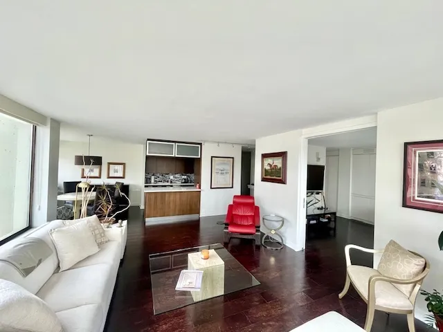 a living room with furniture flat screen tv and window