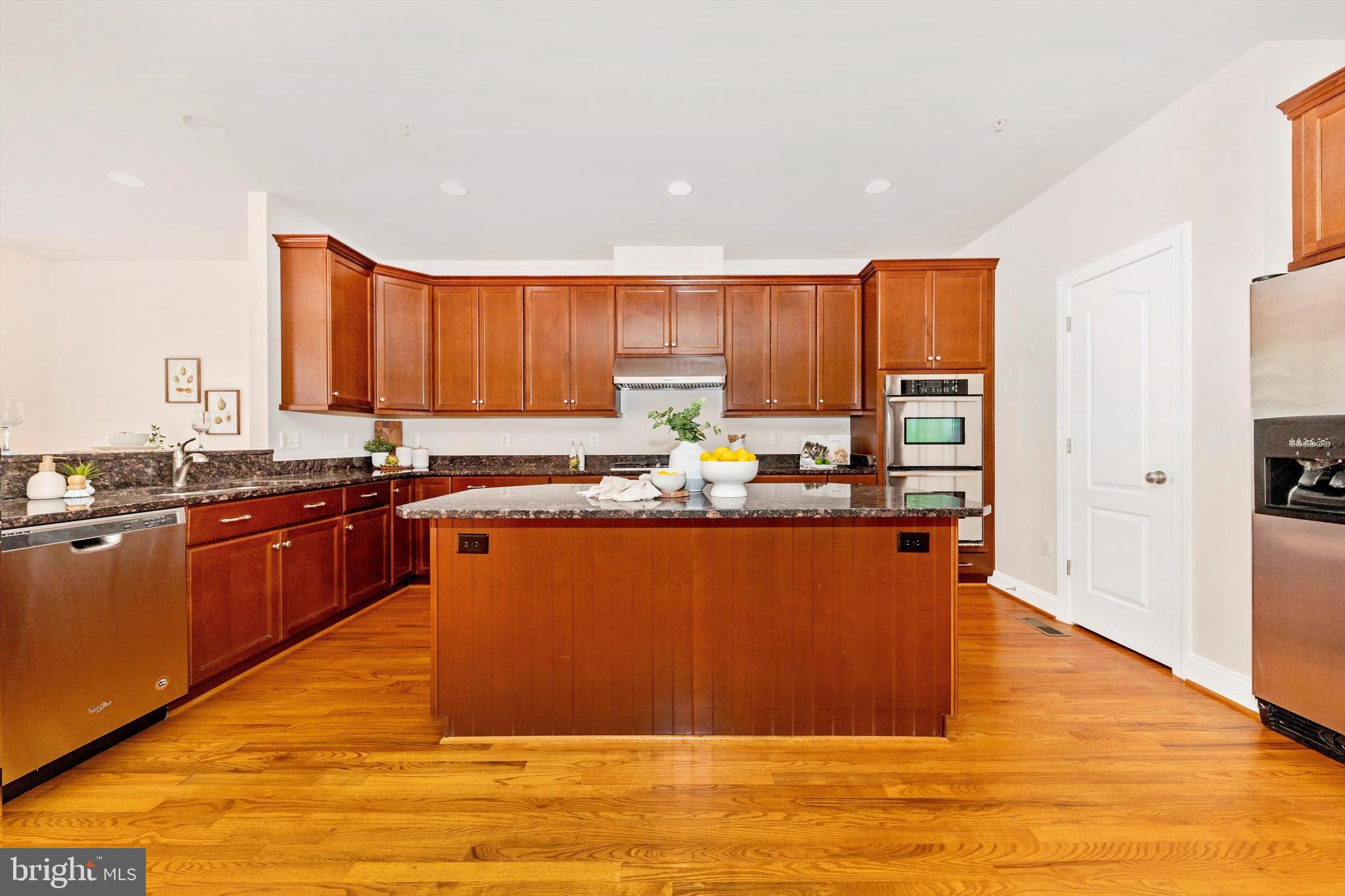 9655 Bothwell Lane Frederick, MD 21704 - Photo 15 of 58 a kitchen with stainless steel appliances granite countertop a refrigerator a sink dishwasher and wooden cabinets with wooden floor