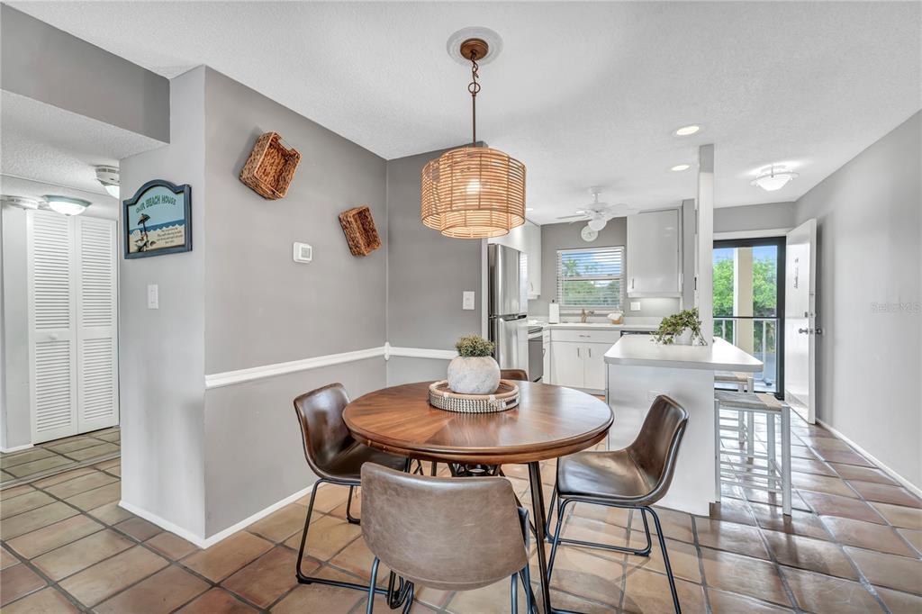 915 Beach Road, Unit 216 Sarasota, FL 34242 - Photo 11 of 30 a dining room with furniture a chandelier and wooden floor