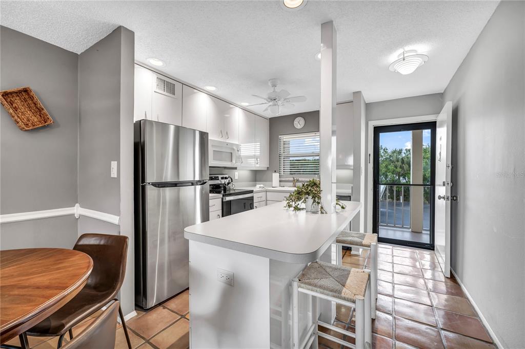 915 Beach Road, Unit 216 Sarasota, FL 34242 - Photo 12 of 30 a kitchen with stainless steel appliances granite countertop a refrigerator and a stove