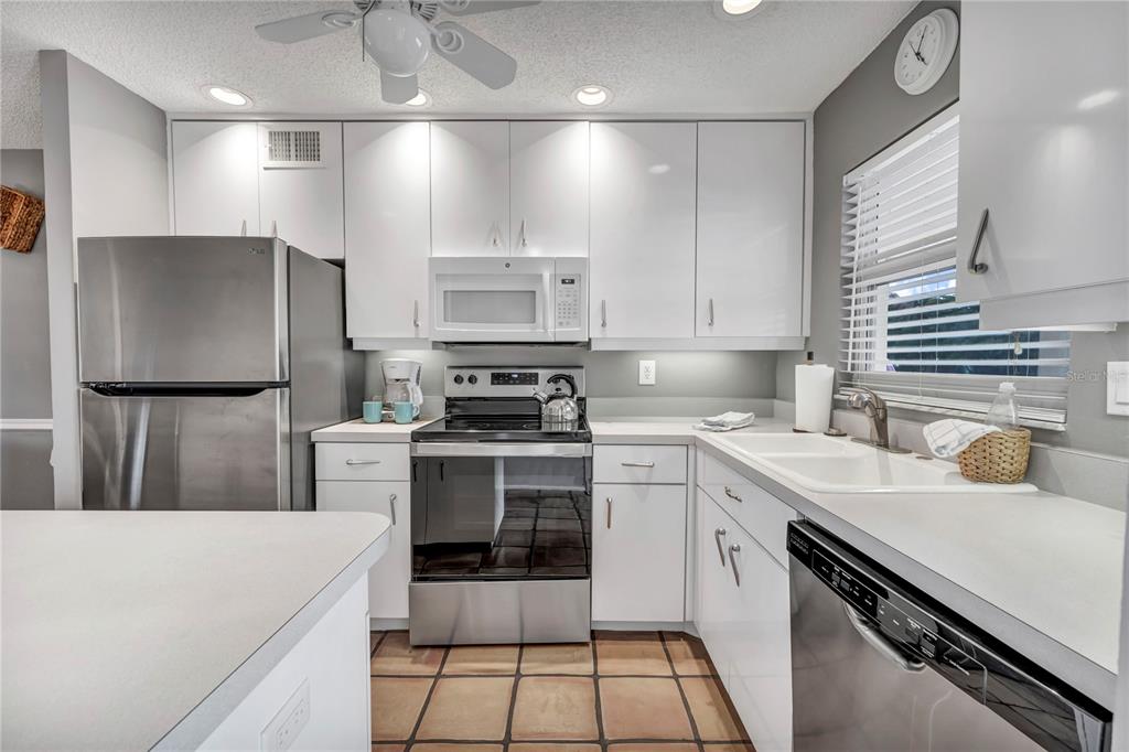 915 Beach Road, Unit 216 Sarasota, FL 34242 - Photo 13 of 30 a kitchen with a sink stainless steel appliances and white cabinets