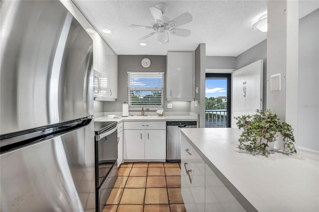 915 Beach Road, Unit 216 Sarasota, FL 34242 - Photo 14 of 30 a kitchen with a sink stainless steel appliances a counter top space and cabinets