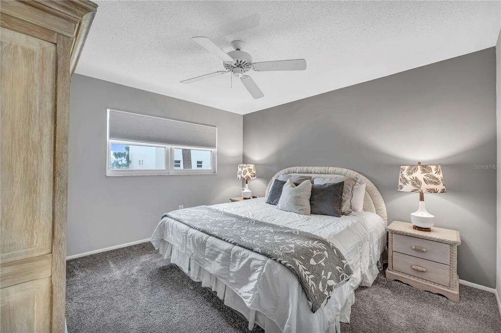 915 Beach Road, Unit 216 Sarasota, FL 34242 - Photo 15 of 30 a bedroom with a bed and a chandelier