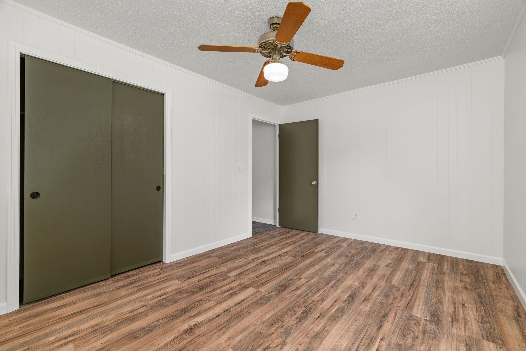 217 Red Bay Road Golden, MS 38847 - Photo 18 of 33 Bedroom featuring wood-finish flooring, a ceiling fan with light fixture, white walls, and a sliding door closet