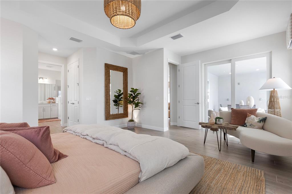 7157 Inlet Isles Lakewood Ranch, FL 34202 - Photo 22 of 26 a spacious bedroom with a bed and a chandelier
