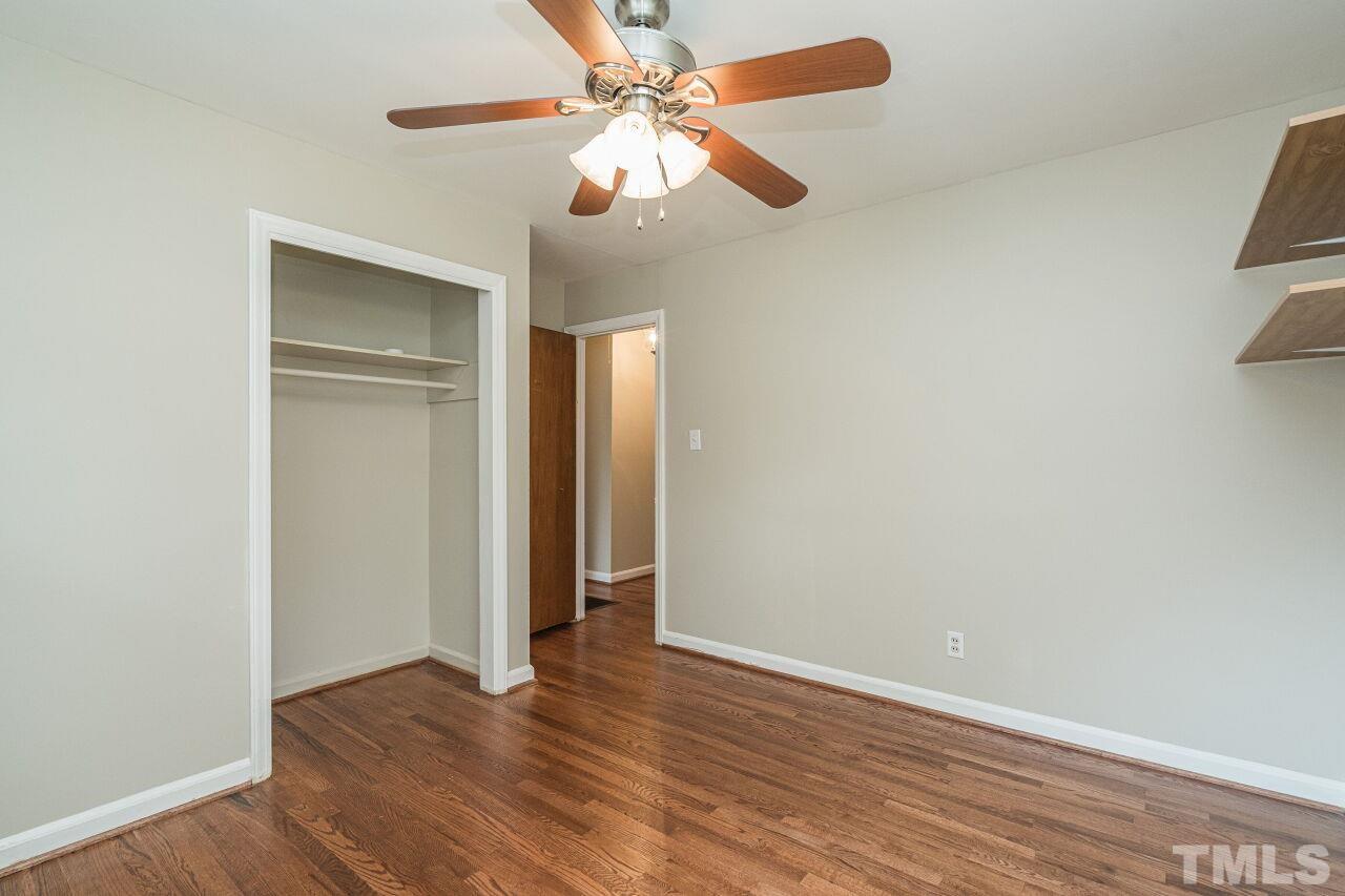 913 Culpepper Lane Raleigh, NC 27610 - Photo 19 of 23 an empty room with wooden floor fan and windows