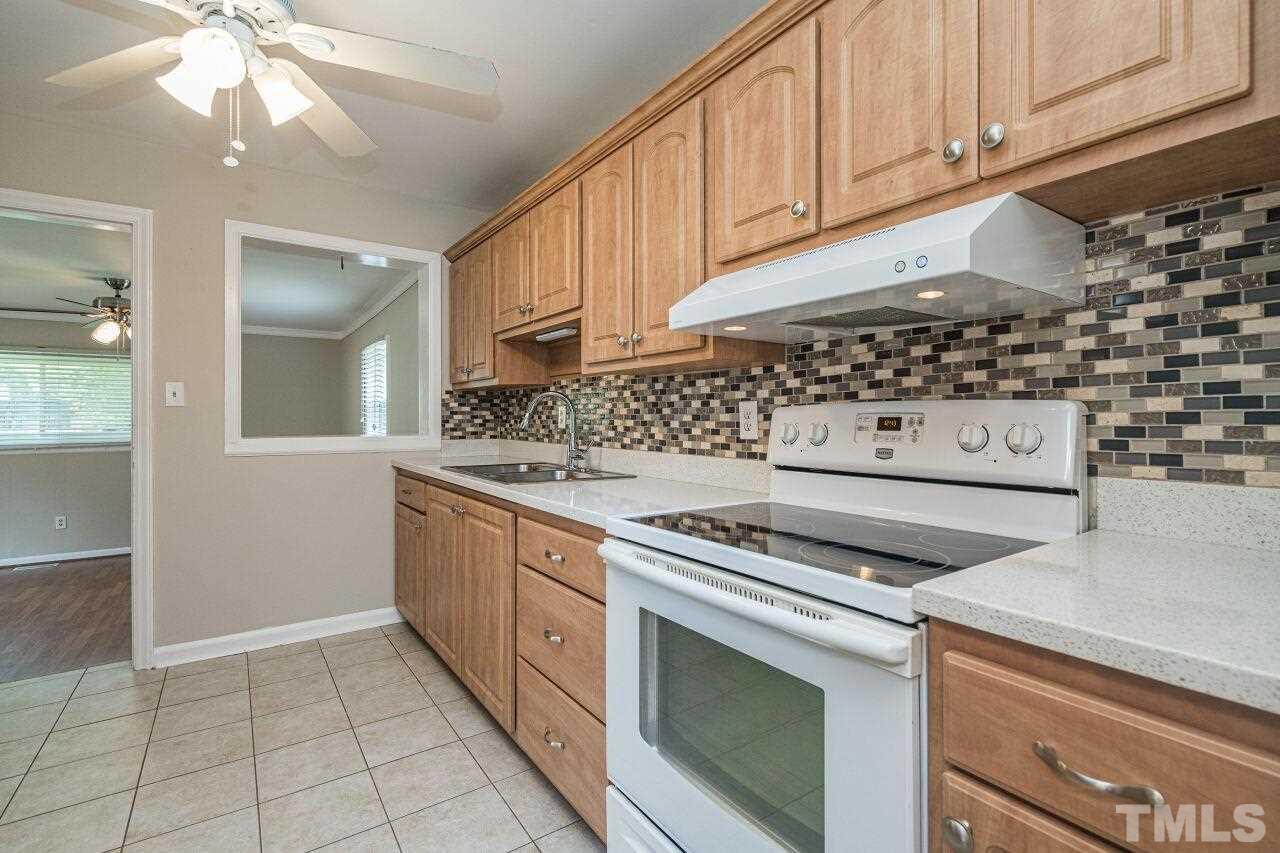 913 Culpepper Lane Raleigh, NC 27610 - Photo 8 of 23 a kitchen with granite countertop a stove sink and cabinets