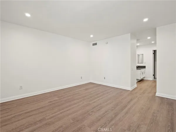 an empty room with wooden floor and empty shelves