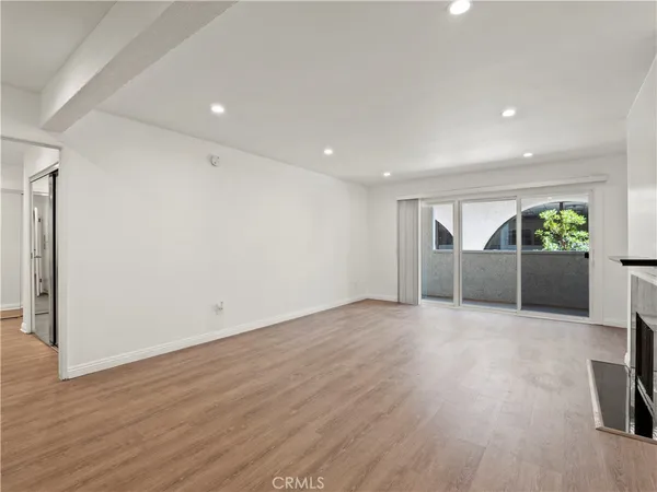an empty room with wooden floor and fireplace