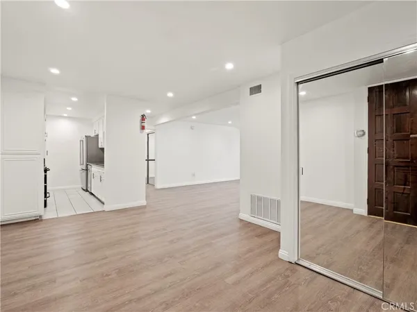 a view of an empty room with wooden floor