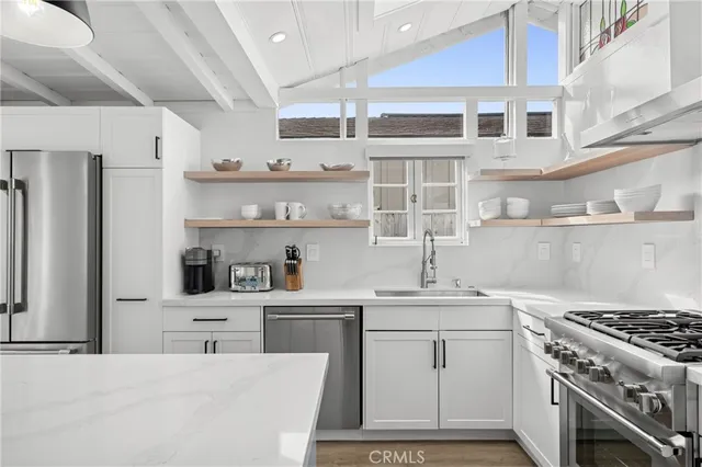 a kitchen with stainless steel appliances a sink stove and cabinets