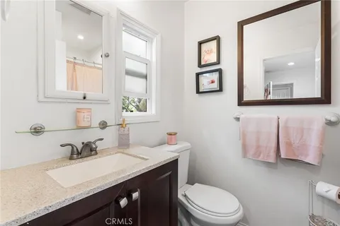 a bathroom with a granite countertop sink mirror and toilet