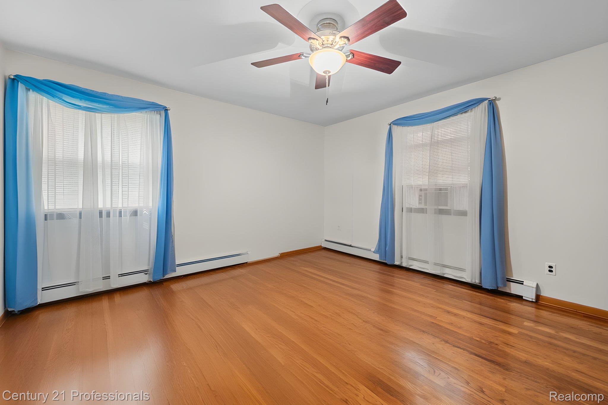 8638 Stone Road Algonac, MI 48001 - Photo 23 of 70 Spare room featuring light wood-style floors, ceiling fan, and baseboard heating
