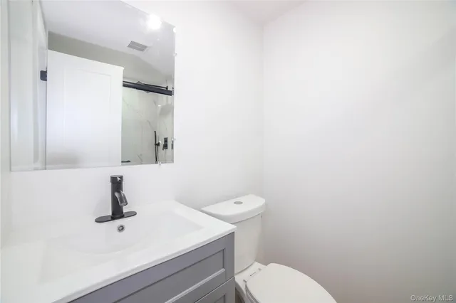 a bathroom with a sink a toilet and mirror
