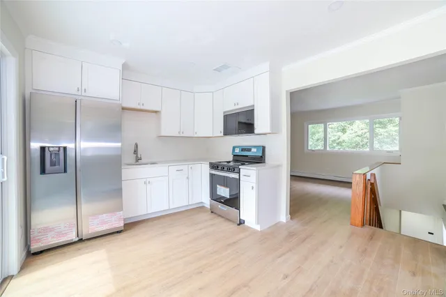 a kitchen with a refrigerator and a stove top oven