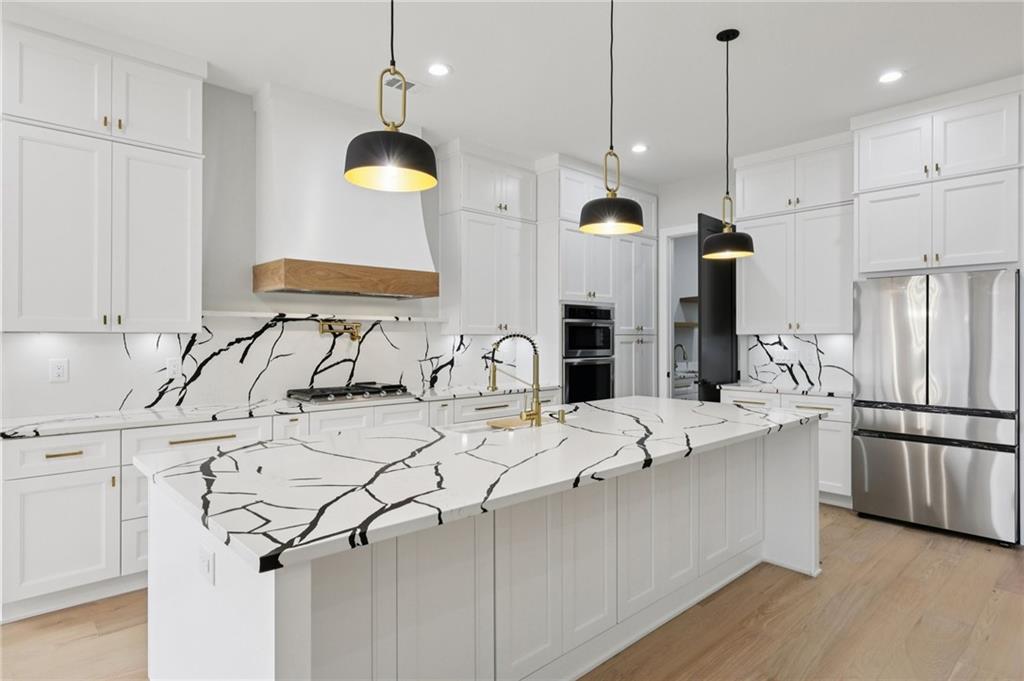 24 Rocking Wood Drive Auburn, GA 30011 - Photo 21 of 66 a kitchen with stainless steel appliances kitchen island a sink refrigerator and cabinets