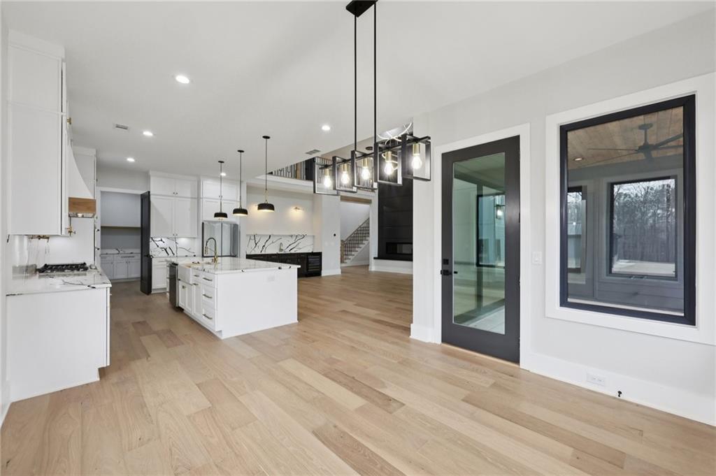 24 Rocking Wood Drive Auburn, GA 30011 - Photo 27 of 66 a large kitchen with stainless steel appliances kitchen island granite countertop a refrigerator a stove and a sink with wooden floor