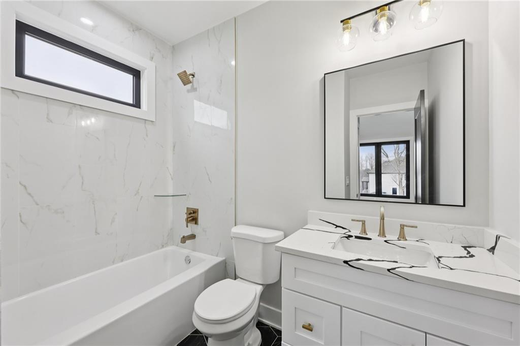 24 Rocking Wood Drive Auburn, GA 30011 - Photo 53 of 66 a bathroom with a granite countertop toilet a sink and bathtub