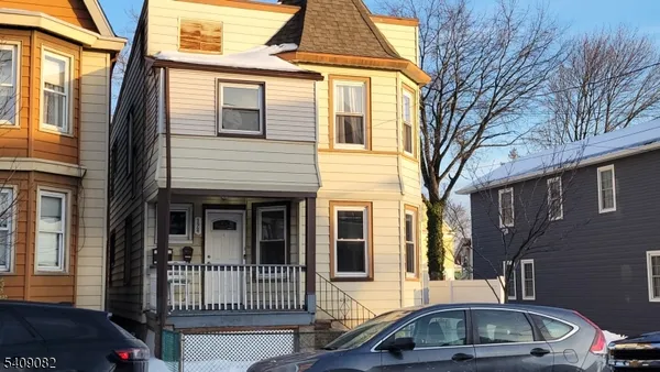 a front view of a house with cars parked