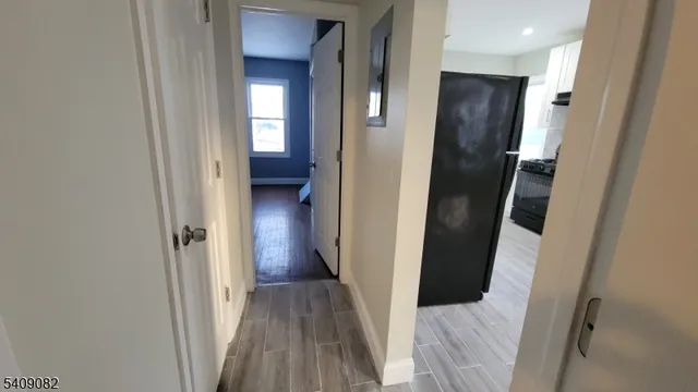a view of a hallway with wooden floor and entryway