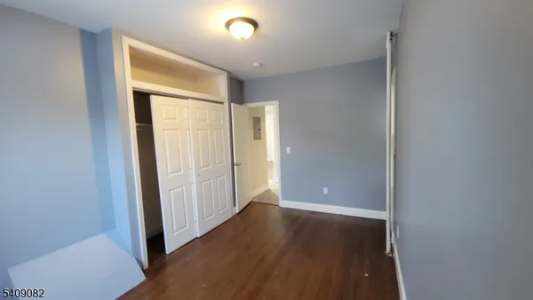 an empty room with wooden floor and entrance