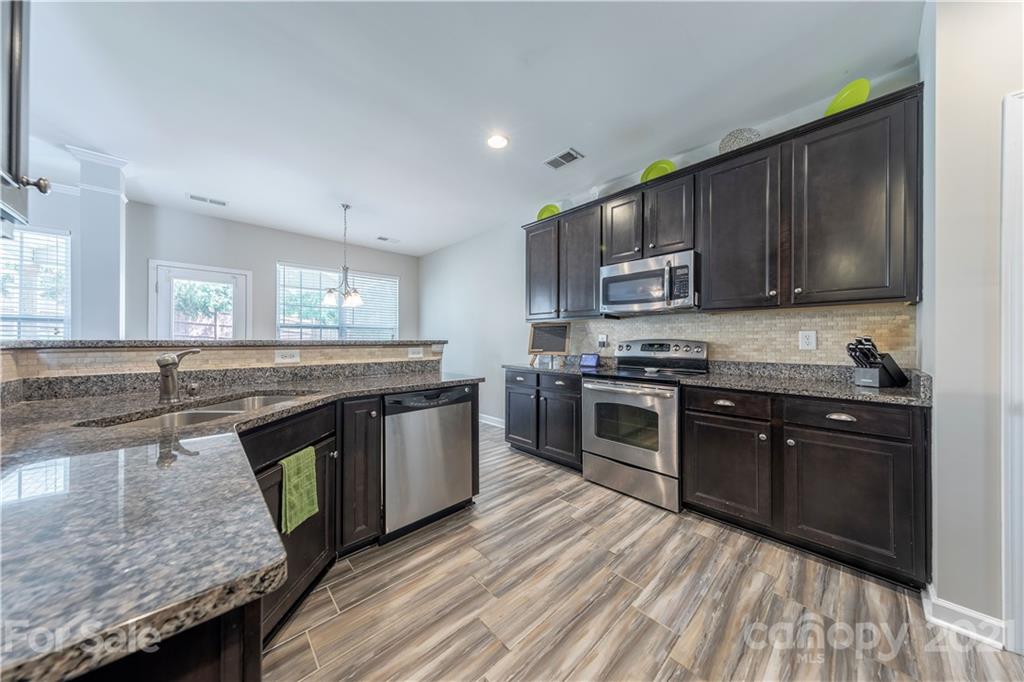 364 Lorraine Road Fort Mill, SC 29708 - Photo 12 of 39 a kitchen with stainless steel appliances granite countertop wooden cabinets a stove top oven a sink and dishwasher