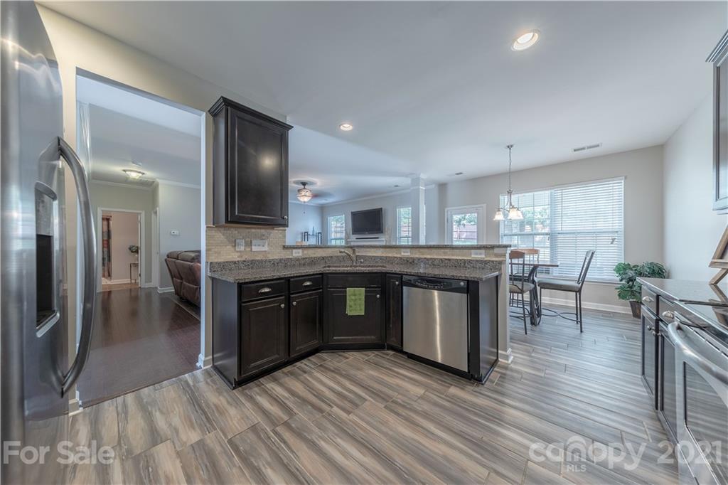 364 Lorraine Road Fort Mill, SC 29708 - Photo 13 of 39 a kitchen with stainless steel appliances granite countertop a stove a sink dishwasher and a refrigerator with wooden floor