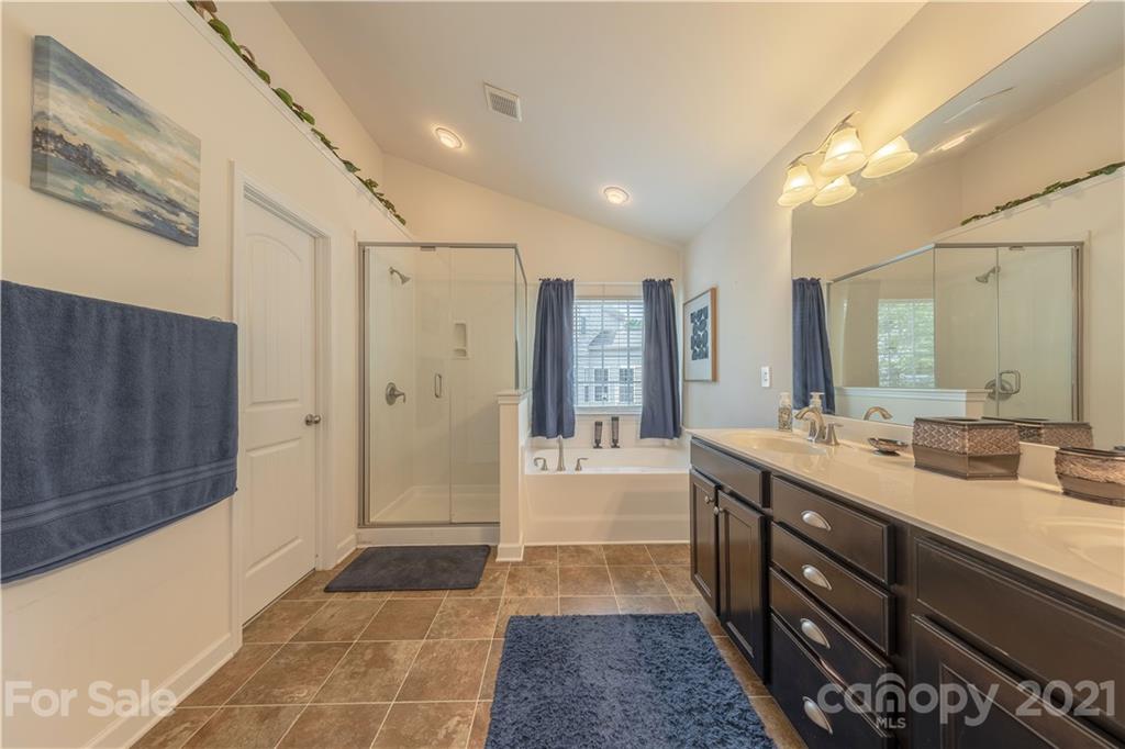 364 Lorraine Road Fort Mill, SC 29708 - Photo 26 of 39 a bathroom with a double vanity sink a large mirror a shower and a bathtub