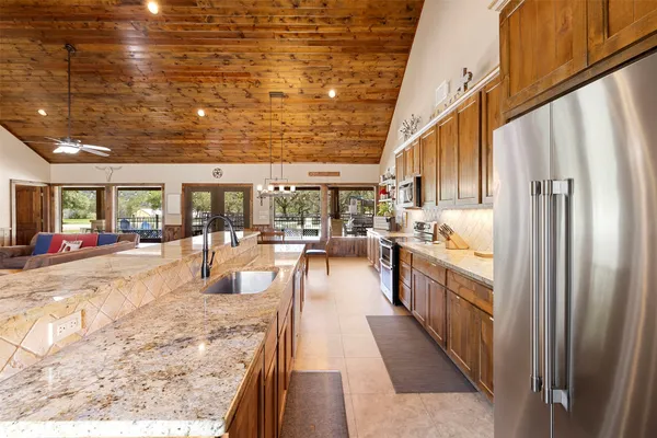 a view of a kitchen with kitchen island granite countertop lots of counter top space