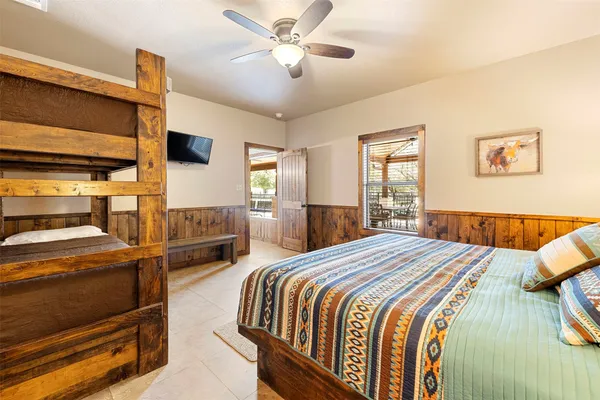 a bedroom with a bed and a tv on the dresser