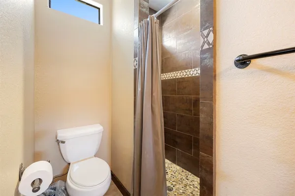 a bathroom with a toilet and a shower