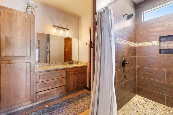 a bathroom with a glass door shower and a sink