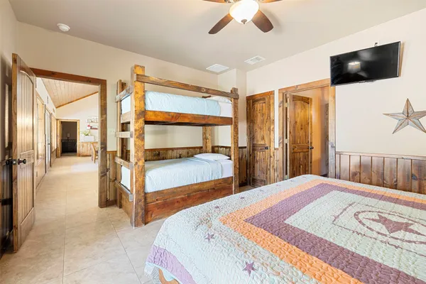 a bedroom with a large bed and a flat tv screen