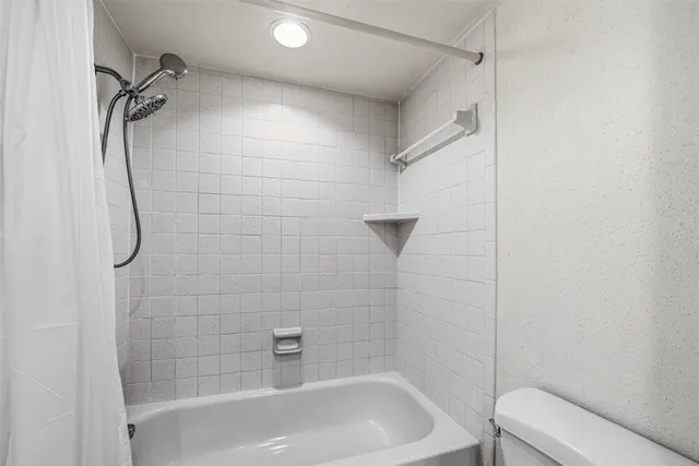a bathroom with a bath tub with a shower