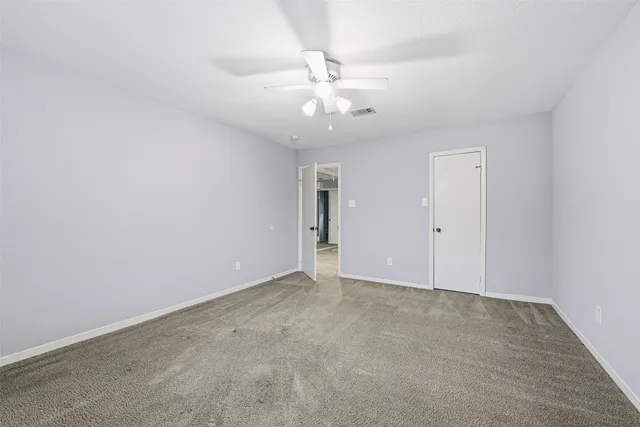 an empty room with a ceiling fan and a window