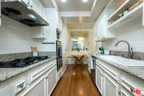 a kitchen with stainless steel appliances granite countertop a sink stove and cabinets