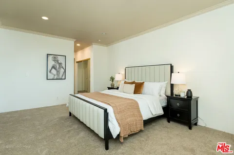a spacious bedroom with a bed and wall painting