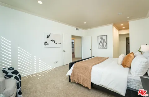 a bedroom with a large bed and a chandelier