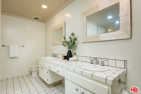 a bathroom with a sink a toilet and mirror