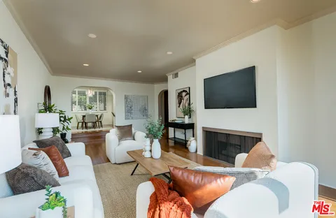a living room with furniture a fireplace and a flat screen tv