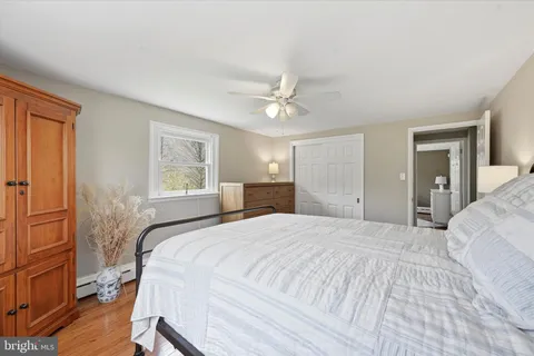 a bedroom with a large bed chandelier and a window