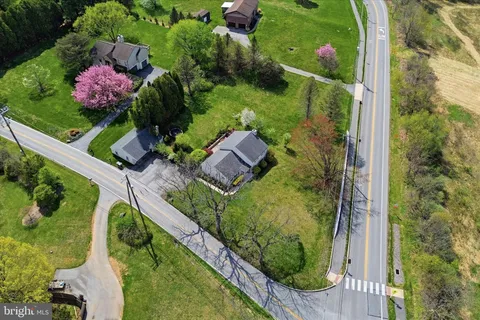 an aerial view of green landscape with trees houses and mountain view